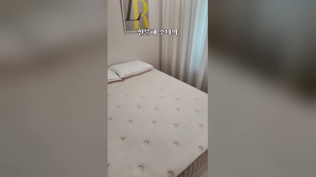이사 준비 매트리스 숏폼 사례 - 베개와 이불로 정리된 침대 위 매트리스와 '선물해 주니까' 자막이 놓인 세로 영상 장면