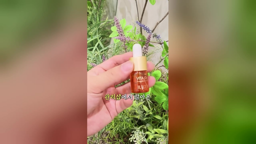 관리샵 앰플 숏폼 광고 사례 - 초록 식물 앞에서 손에 든 주황색 비타민C 앰플 병과 '관리샵에서 알아온' 자막이 보이는 세로 영상 장면